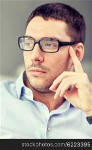 business, people and work concept - portrait of businessman in eyeglasses at office