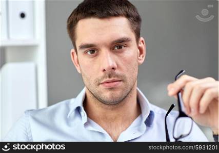 business, people and work concept - portrait of businessman with eyeglasses at office