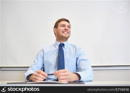 business, people and work concept - smiling businessman sitting in office in front of whiteboard