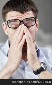 business, people and work concept - tired businessman with eyeglasses in office