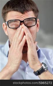 business, people and work concept - tired businessman with eyeglasses in office