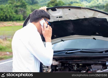 Business people are stressed with broken cars,Opening hood and calling for help on cell phone.