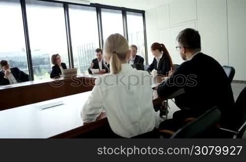 Business people at corporate meeting sitting around the table