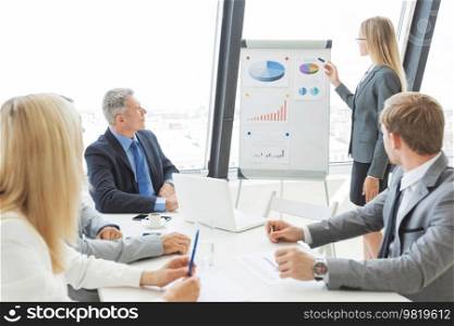 Business people at presentation in office. Businesswoman presenting financial reports on whiteboard.. Business people at presentation in office
