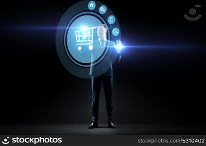 business, people, augmented reality and e-commerce concept - businessman with shopping cart on virtual screen over black background. businessman with shopping cart on virtual screen