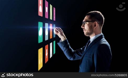 business, people, augmented reality and future technology concept - businessman working with menu icons on virtual screen over black background. businessman with menu icons on virtual screen