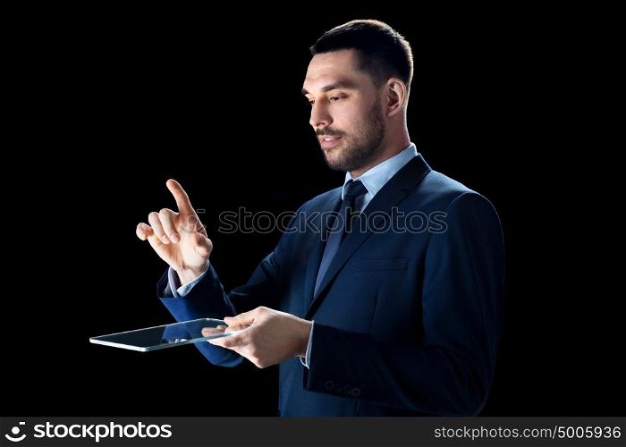 business, people, augmented reality and modern technology concept - businessman in suit working with transparent tablet pc computer over black background. businessman in suit with transparent tablet pc