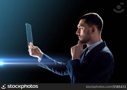 business, people, augmented reality and modern technology concept - businessman in suit working with transparent tablet pc computer over black background. businessman working with transparent tablet pc