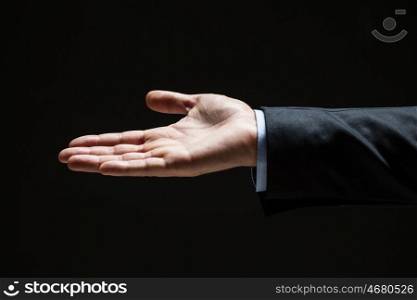 business, people, bankruptcy and advertisement concept - close up of businessman with empty hand over black
