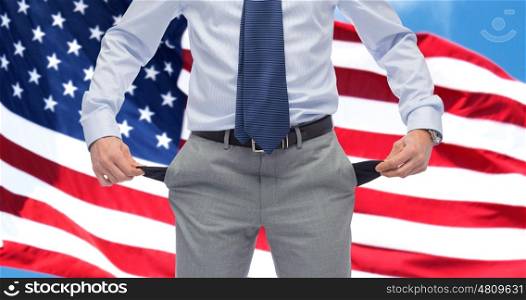 business, people, bankruptcy and failure concept - close up of businessman showing empty pockets over american flag background