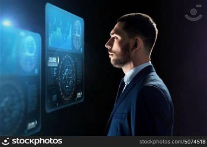 business, people, big data and technology concept - businessman in suit looking at virtual screens projection over black background. businessman looking at virtual screens over black