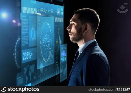 business, people, big data and technology concept - businessman in suit looking at virtual screen projection over black background. businessman looking at virtual screen over black