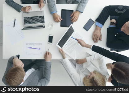 Business people brainstorming at office desk. Business people brainstorming at office desk, analyzing financial reports and working with laptops and tablets