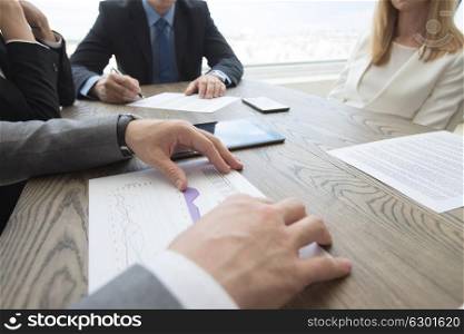 Business people brainstorming at office desk. Business people brainstorming at office desk, analyzing financial reports and working with laptops and tablets