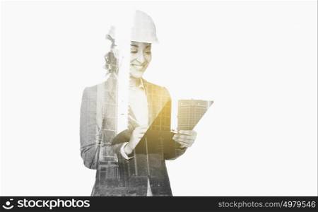 business, people, building, construction and architecture concept - smiling businesswoman in helmet with clipboard over city buildings and double exposure effect. businesswoman in building helmet with clipboard