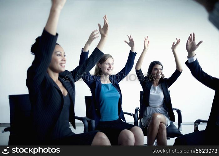 Business people cheering with arms in the air