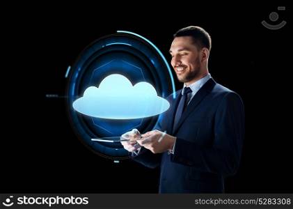 business, people, cloud computing and modern technology concept - businessman in suit working with transparent tablet pc computer and virtual projection over black background. businessman with tablet pc and cloud projection