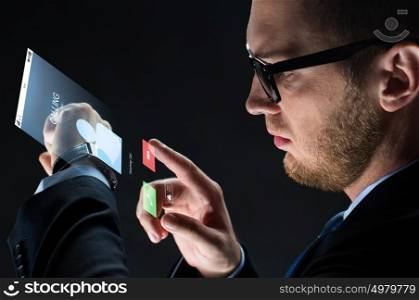 business, people, communication and modern technology concept - close up of businessman with smartwatch and incoming call virtual projection over black background. close up of businessman with smartwatch