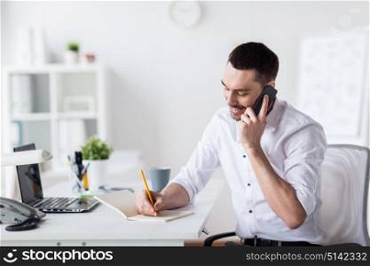 business, people, communication and technology concept - businessman calling on smartphone and writing to notebook at office. businessman calling on smartphone at office