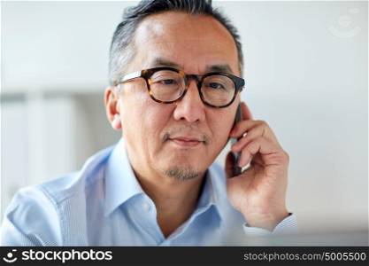 business, people, communication and technology concept - close up of businessman calling on smartphone at office. businessman calling on smartphone at office