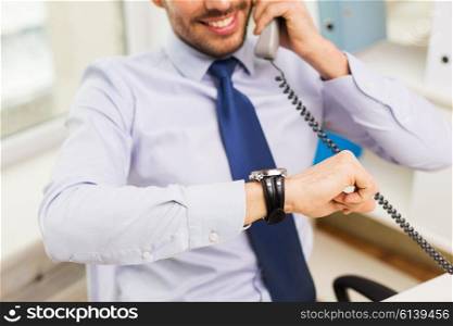 business, people, communication and technology concept - close up of smiling businessman dialing number and calling on phone in office