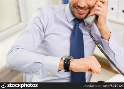 business, people, communication and technology concept - close up of smiling businessman dialing number and calling on phone in office