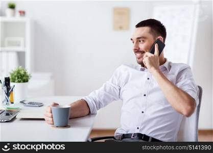 business, people, communication and technology concept - happy businessman with laptop drinking coffee and calling on smartphone at office. businessman calling on smartphone at office