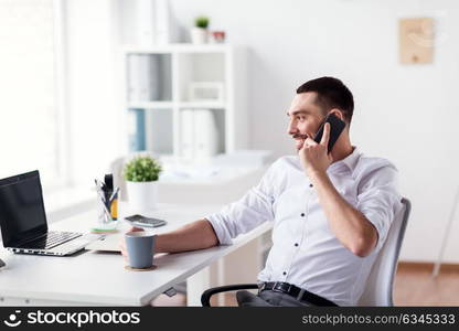 business, people, communication and technology concept - happy businessman with laptop drinking coffee and calling on smartphone at office. businessman calling on smartphone at office