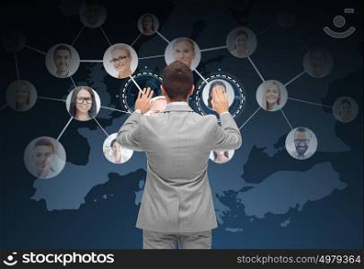 business, people, communication, cooperation and technology concept - businessman touching virtual screen with contacts icons and europe map over dark blue background. businessman using virtual screen with contacts