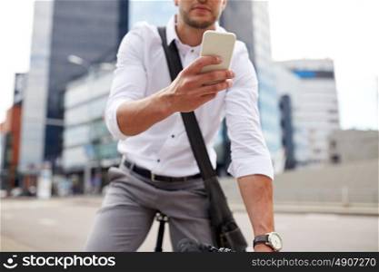 business, people, communication, technology and lifestyle - man texting on smartphone with fixed gear bike on city street. man with smartphone and fixed gear bike on street