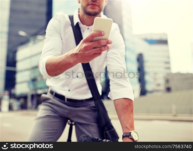 business, people, communication, technology and lifestyle - man texting on smartphone with fixed gear bike on city street. man with smartphone and fixed gear bike on street