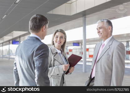 Business people conversing on train platform