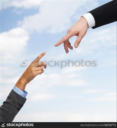business, people, cooperation and connection concept - close up of woman and man hands trying to connect over blue sky background
