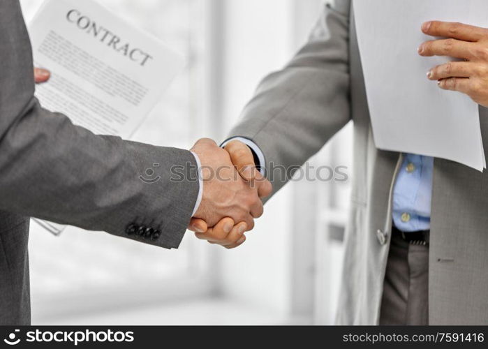 business people, cooperation, partnership and deal concept - close up of businessmen making handshake at office. close up of businessmen making handshake at office