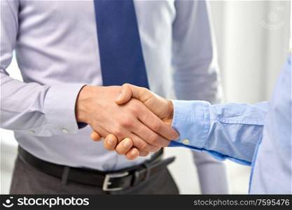 business people, cooperation, partnership and deal concept - close up of businessmen making handshake at office. close up of businessmen making handshake at office