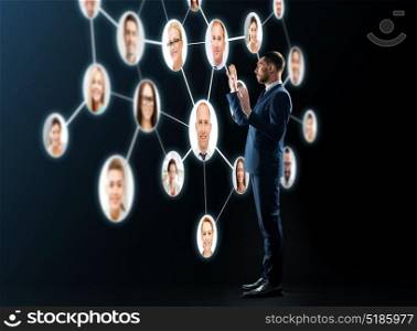 business, people, corporate, headhunting and technology concept - buisnessman in suit looking at contacts network over black background. buisnessman looking at contacts network