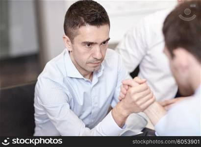 business, people, crisis and confrontation concept - businessmen arm wrestling in office