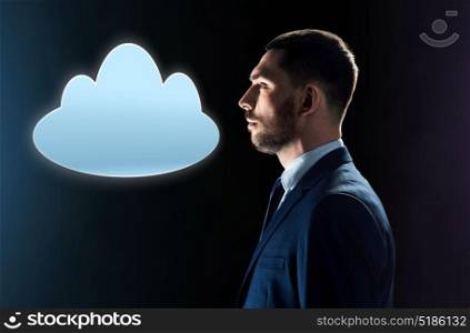 business, people, cyberspace, computing and technology concept - businessman in suit looking at cloud projection over black background. businessman in suit looking at cloud projection