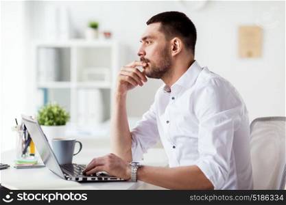 business, people, deadline and technology concept - businessman with laptop computer thinking at office. businessman with laptop thinking at office