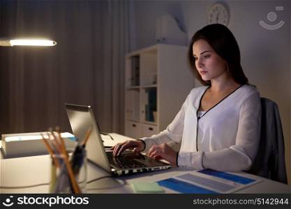 business, people, deadline and technology concept - businesswoman with laptop at night office. businesswoman with laptop at night office