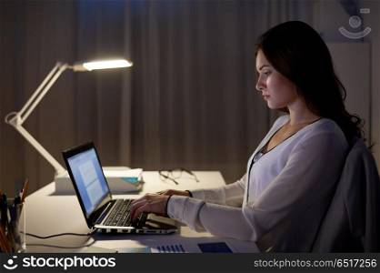 business, people, deadline and technology concept - businesswoman with laptop at night office. businesswoman with laptop at night office. businesswoman with laptop at night office
