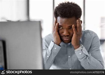 business, people, deadline and technology concept - stressed african american businessman with computer working at office. stressed businessman with computer at office. stressed businessman with computer at office