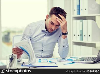 business, people, deadline and technology concept - stressed businessman with laptop computer and papers at office