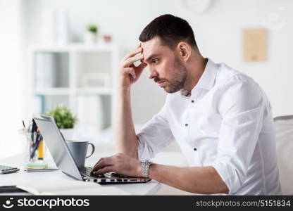 business, people, deadline and technology concept - stressed businessman with laptop computer at office. stressed businessman with laptop at office