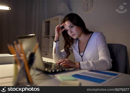 business, people, deadline, stress and technology concept - businesswoman with laptop at night office. businesswoman with laptop at night office