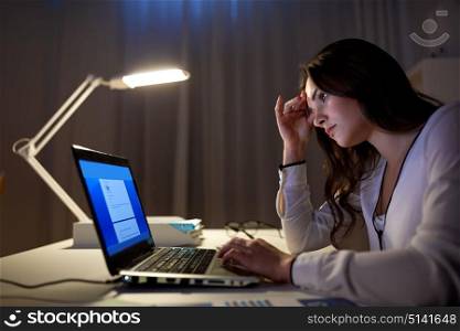 business, people, deadline, stress and technology concept - businesswoman with laptop at night office. businesswoman with laptop at night office