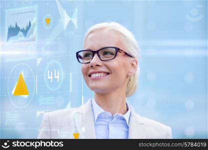business, people, development and future technology concept - young smiling businesswoman in eyeglasses with virtual screen and charts projection outdoors