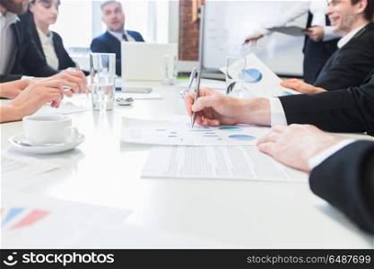 Business people discuss charts. Business people at meeting in office discuss financial charts