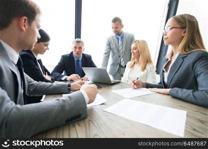 Business people discussing contract. Group of business people and lawyers discussing contract papers sitting at the table