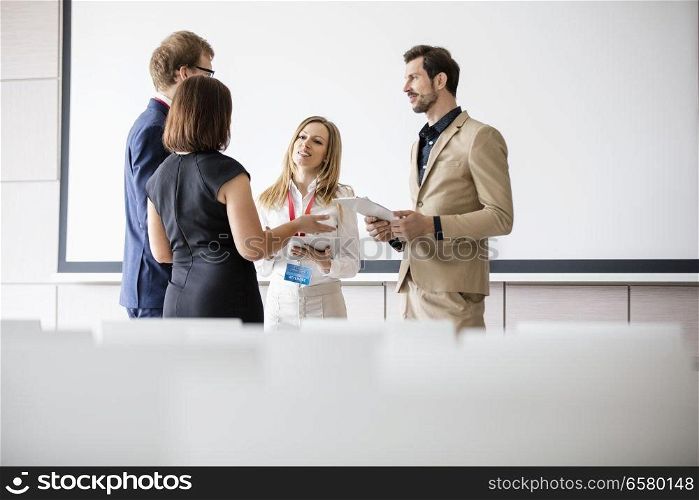 Business people discussing in seminar hall